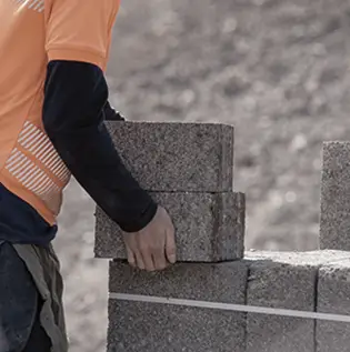 Homme empilant des blocs de béton