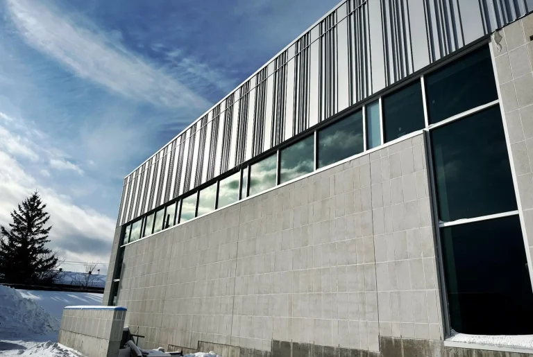 Bâtiment moderne sous un ciel nuageux.